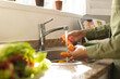 © Wavebreak Media - Midsection of biracial young woman washing carrots at sink in kitchen