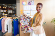 © Wavebreak Media - Portrait of smiling african american female fashion designer showing patterned garment in office