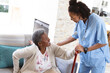 © Wavebreak Media - African american senior woman holding walking cane getting up with help of female doctor at home