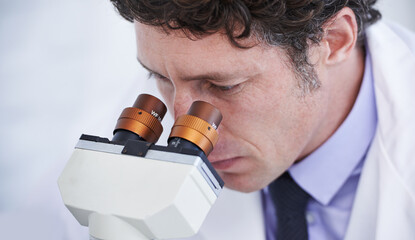 Poster - Life under the microscope. A scientist observing something through a microcope.