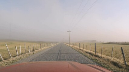 driving on country road heading into a dust storm in idaho on windy day.