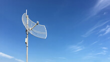 Outdoor Internet Wifi Receiver And Repeater Antenna On The Roof Of The Building With Clear Bluesky Background.