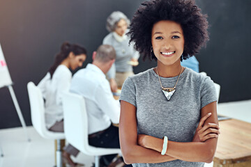 Poster - Feeling positive about my new team. Portrait of a businesswoman standing with her arms folded in the boardroom while a colleague gives a presentation in the background.