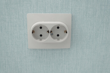 isolated white beige switch and socket on a light wall. aesthetics of electrics, repair, security, interior, design. place for text