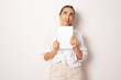 © Danko - Image of young brunette woman, company worker, doubtful and holding digital tablet, standing over white background