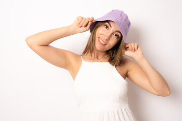 young beautiful brunette woman wearing casual dress and summer hat over white background smiling wit