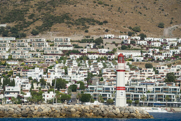 Red lighthouse at entrance to D-Marin (Dmarin) Turgutreis. Flagship marina is located near Bodrum and features award-winning marina village and heliport, Turkey. City view