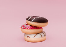 Doughnuts. Photo In Minimal Style. Mixed Frosted Sprinkled Donuts On Pink Backdrop 
