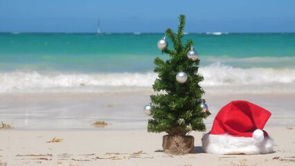 Wall Mural - Christmas fir tree and Santa Claus Hat on sandy beach. Caribbean New year celebration. Nobody