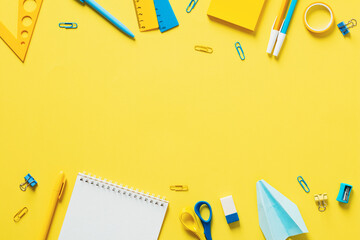 Wall Mural - Blue and yellow school supplies and stationery on yellow table. Flat lay, top view, copy space. Back to school concept.