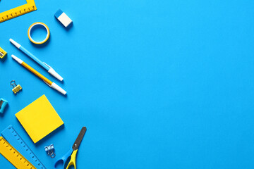 Wall Mural - Flat lay blue and yellow office stationery on blue background. Back to school concept. School supplies top view.