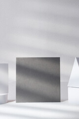 Poster - blank grey poster card with product display stand with sunlight in white studio