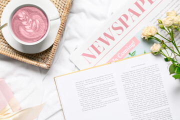 Wall Mural - Cup of pink matcha tea with book, newspaper and rose flowers on bed