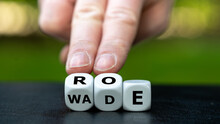 Symbol Of The Abortion Process Roe Versus Wade. Hand Turns Dice And Changes The Word Wade To Roe.