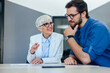 © bnenin - Mature businesswoman having a conversation with young male client.