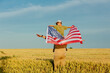 Father with son and USA flag on wheat field