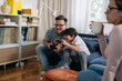 © cherryandbees - father and son playing video games at home