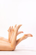 © Lustre Art Group  - Image of slender female legs isolated over grey studio background. Smooth skin. Depilation, epilation body care