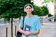 © Valerii Honcharuk - Smiling teenage male student with textbooks looking at camera outdoor