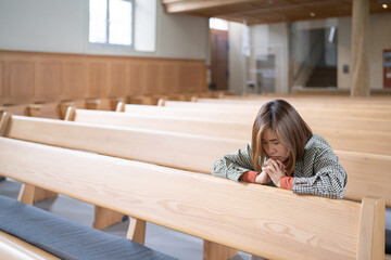 Wall Mural - A Christian female is sitting and praying.