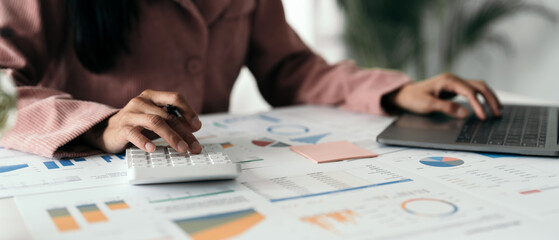 Wall Mural - Close up hand of woman using computer calculating household finances or taxes on machine, female manage home family expenditures, using calculator, make payment on laptop