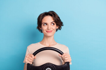 Poster - Photo of dreamy cute lady dressed beige t-shirt driving vehicle looking empty space isolated blue color background