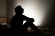 © Octavian - Male silhouette depicting loneliness or depression sitting in his apartment bed