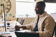 © Southworks - Young Black Male Advertising Marketing Or Design Creative In Office Sitting At Desk Working On Computer