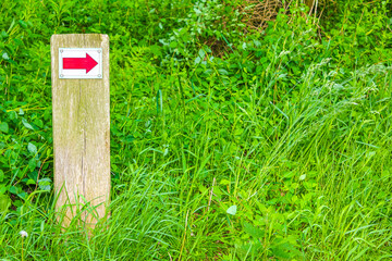 North German red arrow directional sign meadow forest nature Germany.