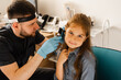 © Rabizo Anatolii - ENT doctor otolaryngologist looks through otoscope the ears of a little girl. Otoscopy. Treatment child ear pain.