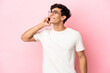 © luismolinero - Young Argentinian man isolated on pink background keeping a conversation with the mobile phone