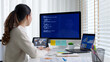 © ChayTee - Asia young business woman sit busy at home office desk work code on desktop reskill upskill for job career remote self test IT deep tech ai design skill online html text for cyber security workforce.