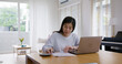 © ChayTee - Adult asia people single mom small SME owner support happy sit busy apply child tax credit refund plan form app or pay loan bill on laptop. Little kid girl play at home hybrid job career workforce.
