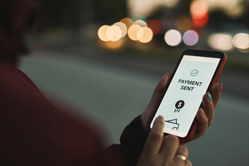 Money transfer. Online banking. Person transferring money online using applications to send and receive money on smartphones. Smartphone screen displaying money transfer confirmation