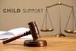 © New Africa - Judge's gavel, scales of justice and book on wooden table. Child support concept