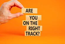 Right Track Symbol. Concept Words Are You On The Right Track On Wooden Blocks On A Beautiful Grey Table Orange Background. Businessman Hand. Business Motivational And Right Track Concept.