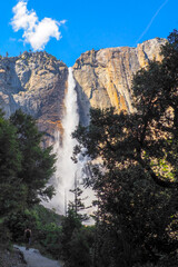 Wall Mural - Vertical shot of Upper Yosemite Fall on a beautiful sunny summer day, Epic waterfall under blue sky in Yosemite National Park, California, USA. Natural wonders of the world.