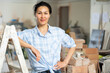 Portrait of positive smiling young adult woman owner of apartment ready to be renovated standing at indoor construction site