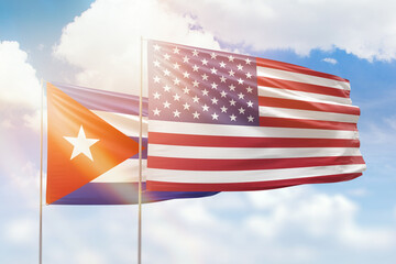 Wall Mural - Sunny blue sky and flags of united states of america and cuba