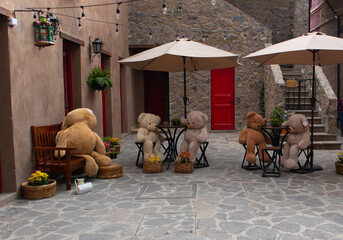 Big Teddy bears at the table in a street restaraurant in a new medieval italian tuscany style town villa in Val'Quirico, Tlaxcala, Puebla, Mexico