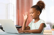 © Pixel-Shot - Little African-American girl video chatting with laptop at home