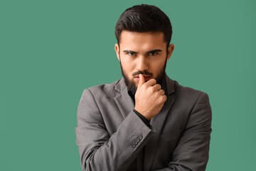 Wall Mural - Portrait of pensive bearded man on green background