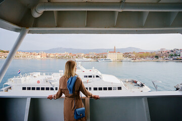 Wall Mural - Voyage or cruise. Young woman enjoying view on ship deck. Sailing the sea.