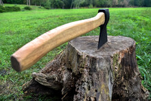 The Ax Is Stuck In A Dry Stump, Against The Backdrop Of Nature. Human And Nature