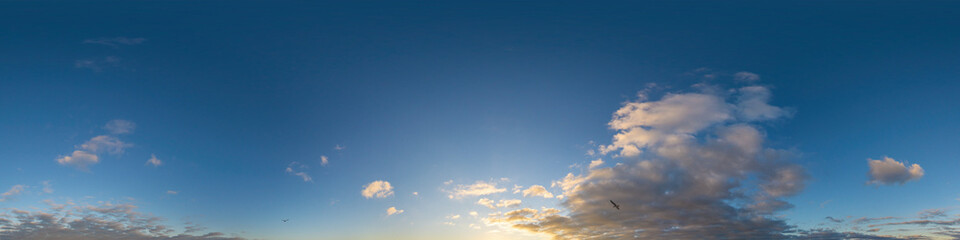 panorama of a dark blue sunset sky with golden cumulus clouds. seamless hdr 360 panorama in spherica