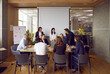 © Studio Romantic - Cheerful and smart colleagues are discussing their new business project at brainstorm in office. Group of business men and women sitting at conference table in modern office center with loft interior.