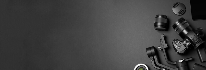 Poster - Flat lay composition with camera and video production equipment on black background, space for text. Banner design