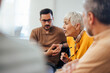 © bnenin - Side view of a mature woman, looking upset, talking to others from the group therapy.