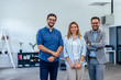 © bnenin - Portrait of three business colleagues, two males, and one female, standing and posing for the camera.