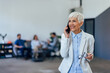 © bnenin - Portrait of a smiling businesswoman, making a phone call at the office.